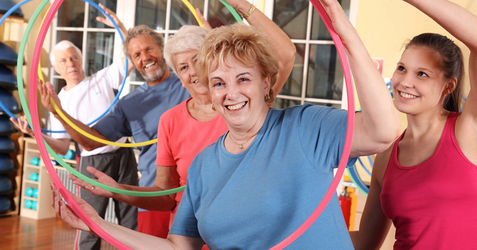 Stroke Risk Factors, Picture of a group of caucasian people exercising with hula hoops with an instructor